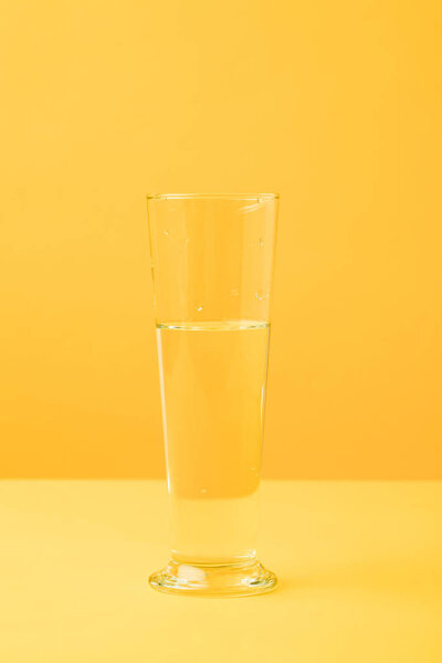 close-up view of glass vase with water on yellow