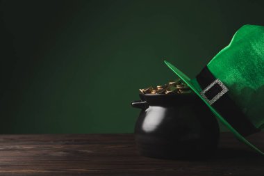 pot altın sikke ve yeşil şapka masada, st patricks günü kavramı