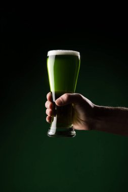 cropped image of man holding glass of green beer, st patricks day concept clipart