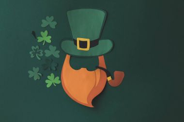 top view of paper decoration of smoking man and shamrock for st patricks day isolated on green clipart