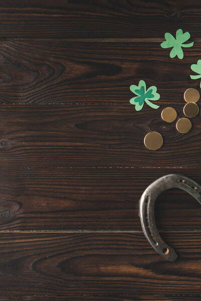 top view of golden coins, horseshoe and shamrock on wooden table, st patricks day concept