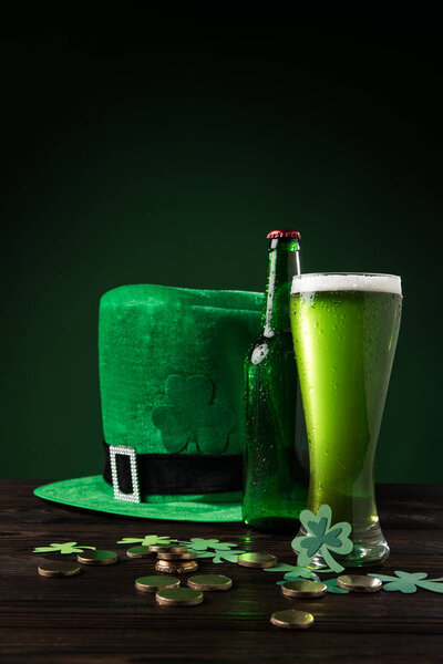 green hat with green beer and coins on table, st patricks day concept