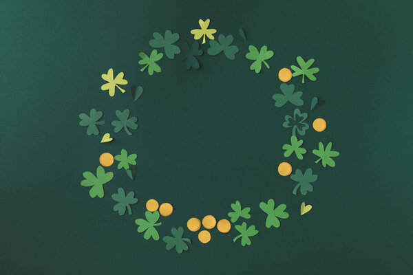 верхний вид бумажного украшения монет и трилистника для Святого Патрика день изолирован на зеленый
