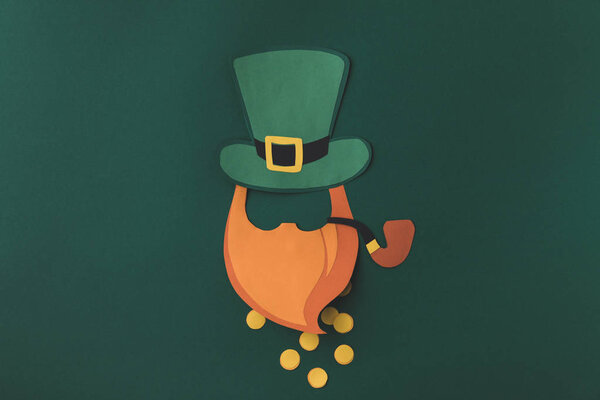 top view of paper decoration of leprechaun in green hat with coins for st patricks day isolated on green