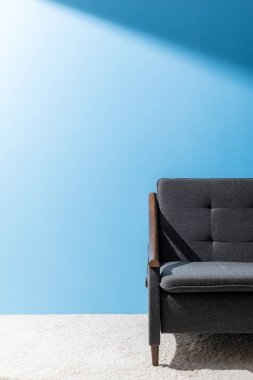 mavi duvar önünde rahat gri kanepe