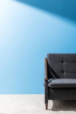 comfy grey couch in front of blue wall clipart