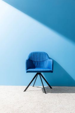 comfy blue chair in front of blue wall clipart