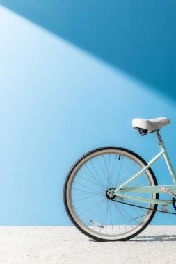 back wheel of bicycle in front of blue wall clipart
