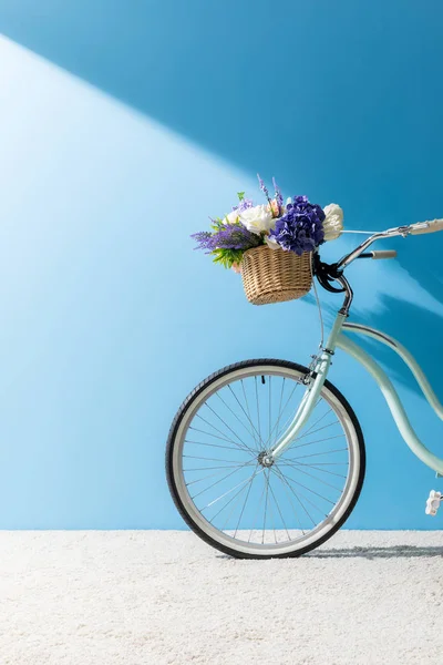 Fahrrad Mit Blumen Korb Steht Auf Teppich Vor Blauer Wand — Stockfoto