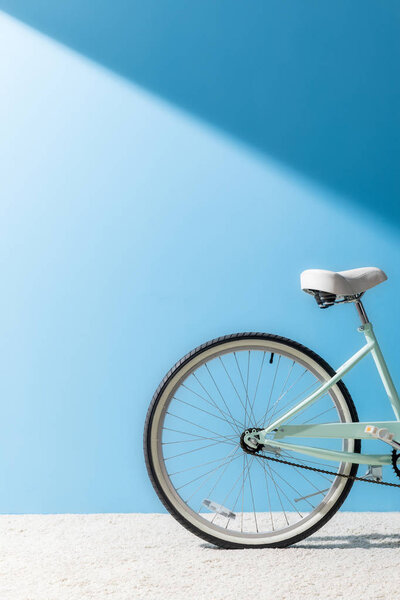 back wheel of bicycle in front of blue wall