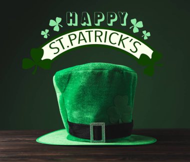 close up view of green hat on wooden surface and happy st patricks lettering clipart