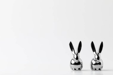 Beyaz gümüş Paskalya tavşanları iki heykelcikler