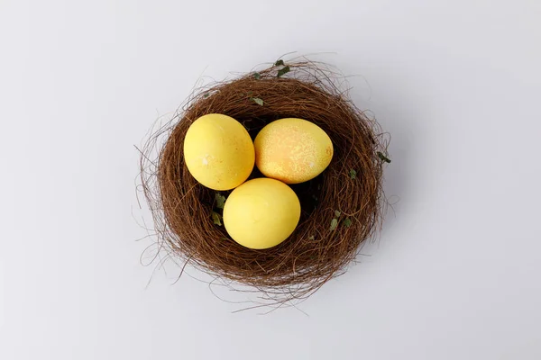 白色装饰巢中黄色彩绘复活节彩蛋的顶部视图 — 图库照片