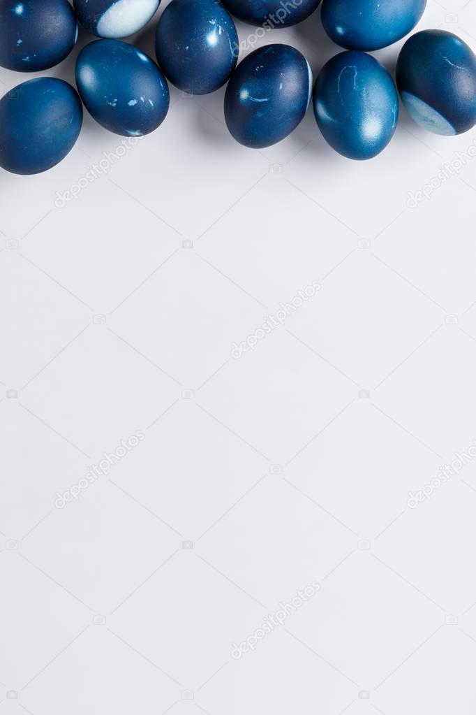 top view of blue painted easter eggs on white