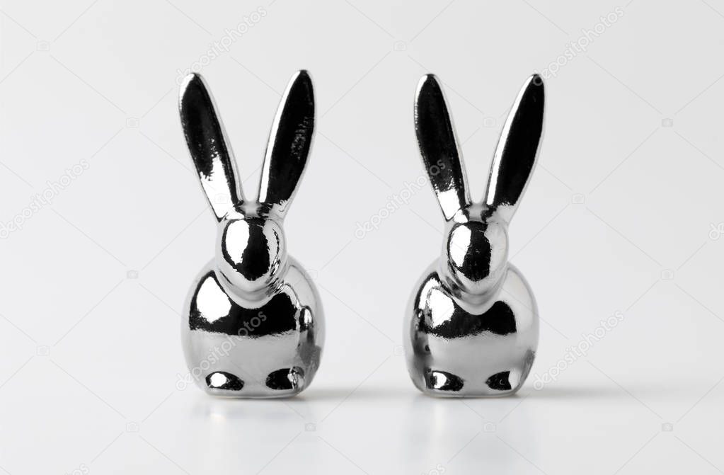 two statuettes of easter rabbits on white