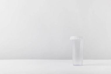 Beyaz masa üzerinde bir plastik bardak