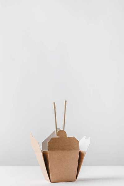 noodles box with chopsticks on white table