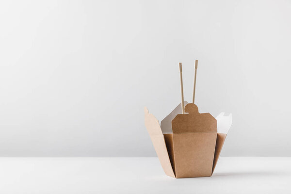 noodles box with chopsticks on white tabletop