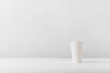 white disposable coffee cup on white tabletop