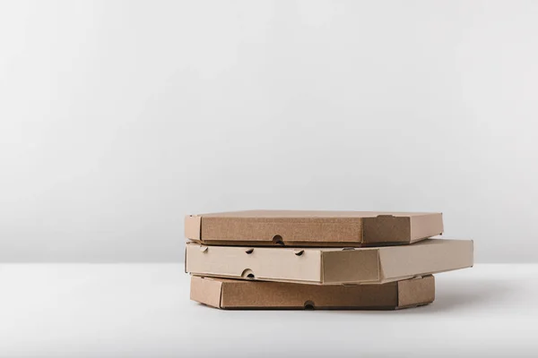 白色桌面上的三个比萨饼盒 — 图库照片