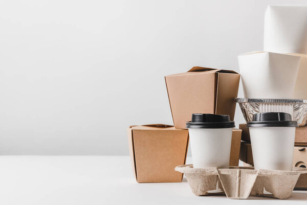 fast food in different containers and take away boxes on table