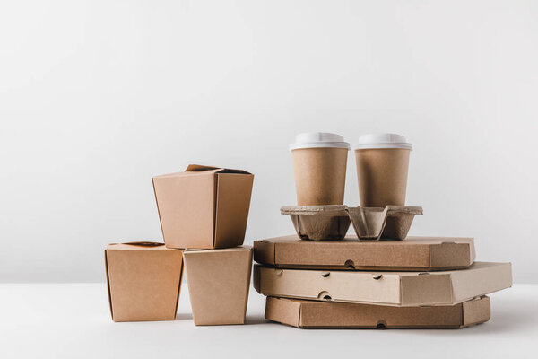 pizza boxes and disposable coffee cups with noodles boxes on surface