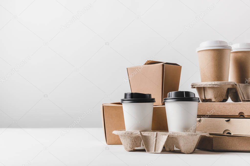 pizza boxes and coffee to go with noodles boxes on tabletop