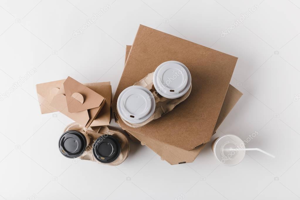top view of pizza boxes and coffee to go with food containers on tabletop