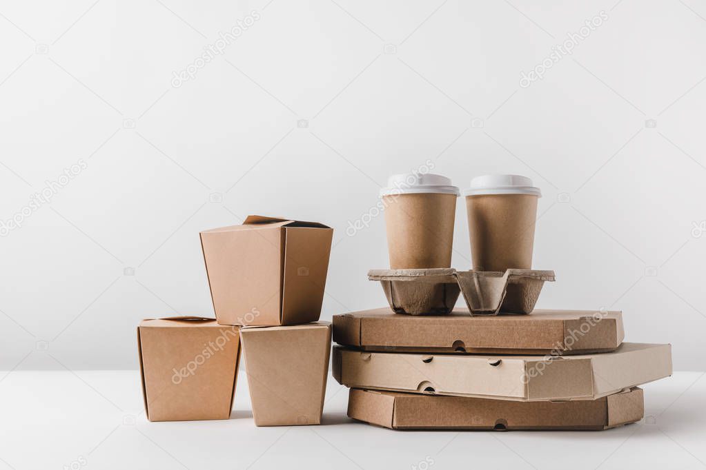 pizza boxes and disposable coffee cups with noodles boxes on surface