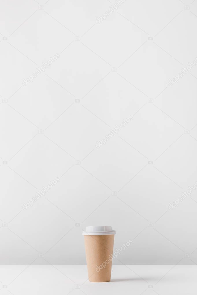 one disposable coffee cup on white table