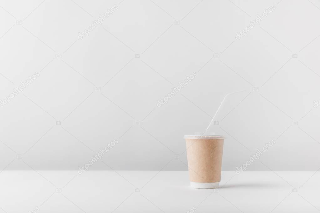 one disposable coffee cup on white tabletop