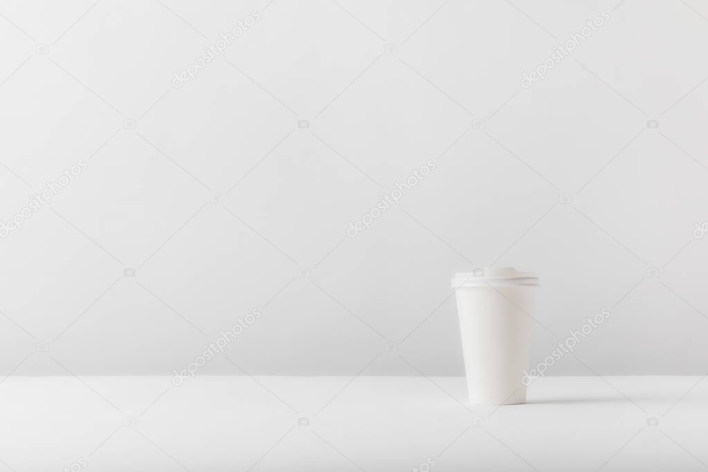 White disposable coffee cup on white tabletop
