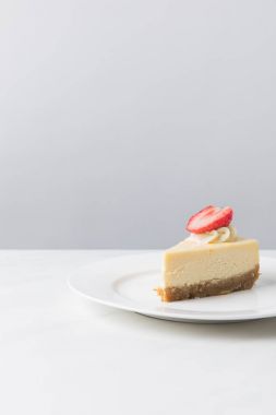 Cheesecake taze çilek beyaz plaka üzerinde parça ile