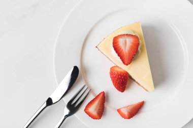 Tarafından dilimlenmiş çilek cheesecake çevreleyen ile plaka 