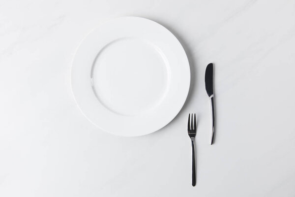 Верхний вид тарелки с вилкой и ножом, концепция столиков
