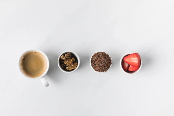 Ovanifrån Kaffekopp Och Skålar Med Valnötter Jordgubbar Och Riven Choklad — Stockfoto