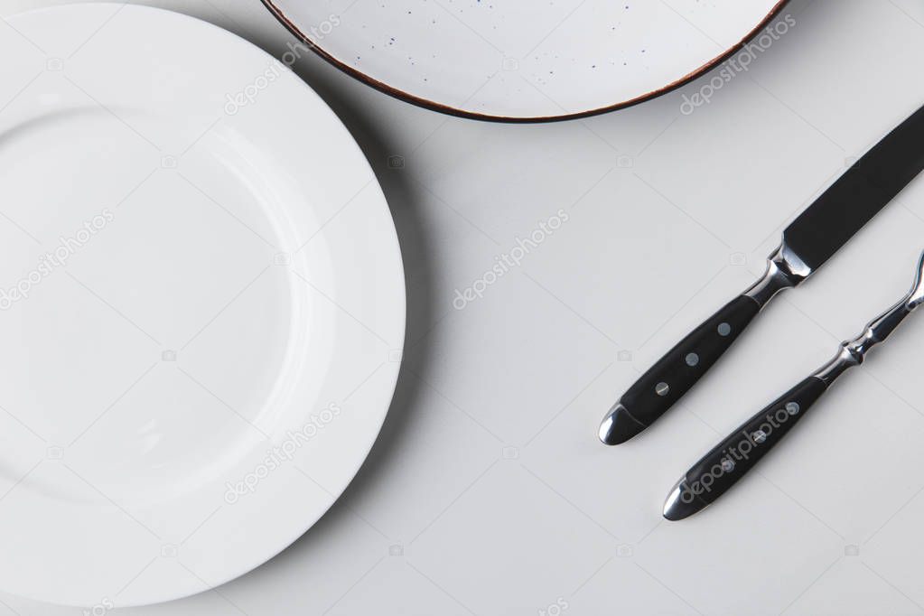 Two different plates with cutlery, table appointments conception