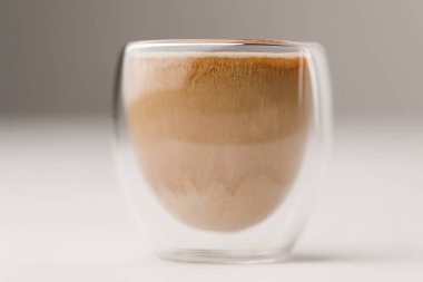Glass cup filled with coffee with milk on white background clipart