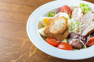 gurme Sezar salatası ahşap masa üzerinde görmek