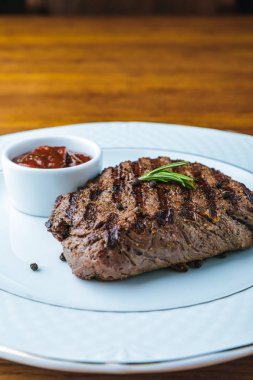 lezzetli ızgara biftek biberiye ve Barbekü sos plaka üzerinde