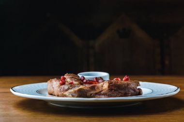 close-up view of delicious grilled steaks with pomegranate seeds on plate clipart