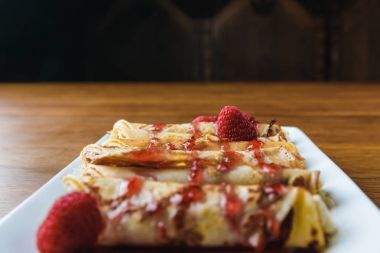 Ahududu ve reçel krep tatlı yakın çekim görünümünü haddelenmiş