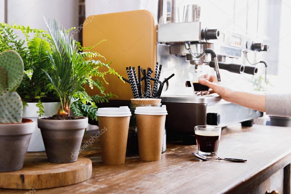 Close-up view of bartender preparing coffee on modern espresso machine