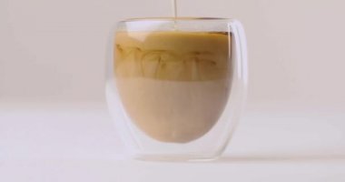 Beyaz arka plan üzerinde süt Kupası kahve ile dökme