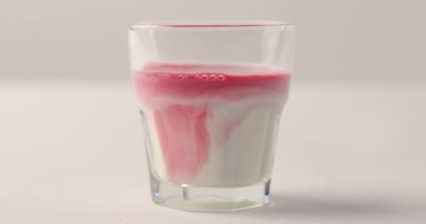 Rode Siroop Toevoegen Aan Glas Met Melk Witte Achtergrond Met — Stockvideo