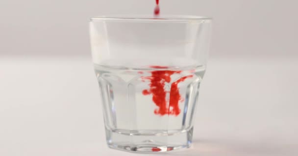 Versare Sciroppo Rosso Vetro Con Acqua Fondo Bianco Con Filmato — Video Stock