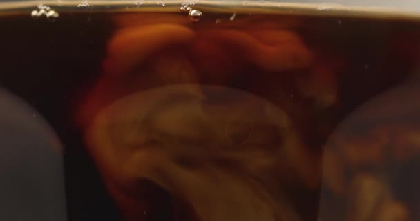 Vue rapprochée de l'ajout de lait en verre avec café noir 