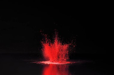 red holi powder explosion on black, traditional Indian festival of colours