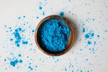 top view of blue holi paint in bowl isolated on white, Hindu spring festival clipart
