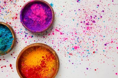 top view of colorful holi powder in bowls isolated on white, traditional Hindu spring festival clipart